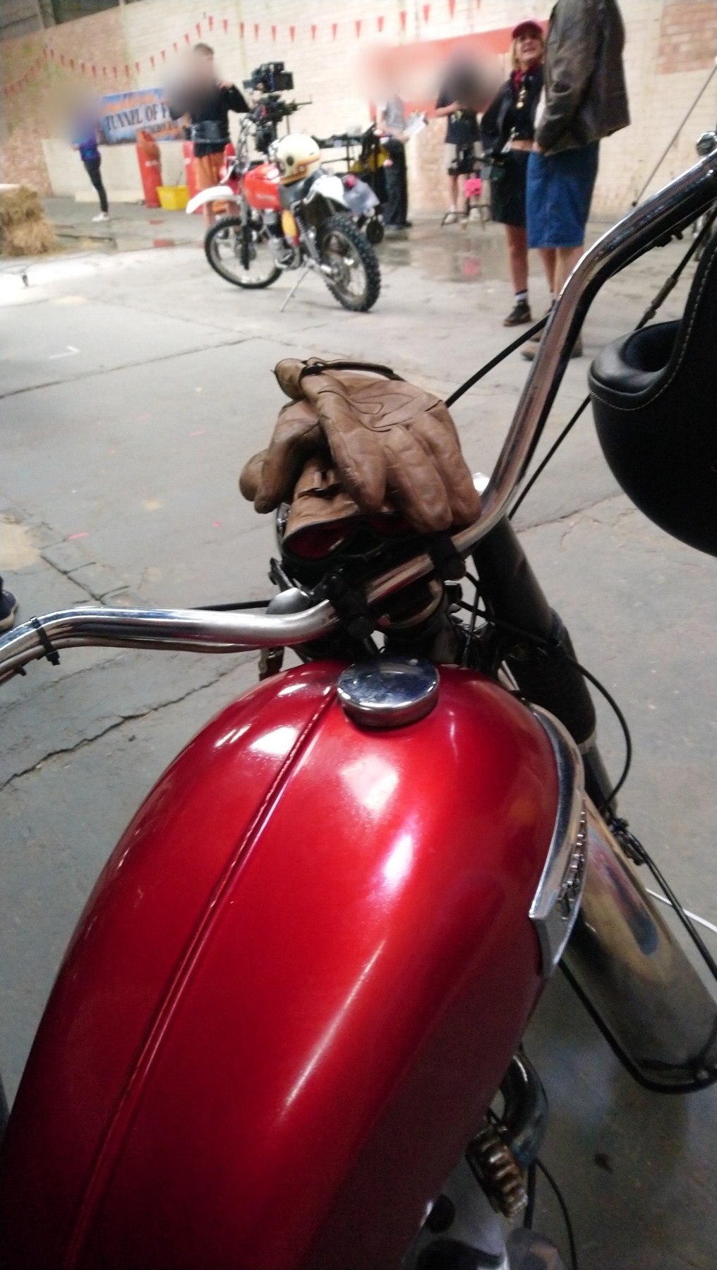 Close-up of a red Triumph tank and gloves on set